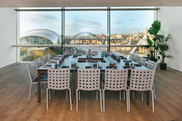 Large table set up for a meeting with a view over the river Tyne in the background.