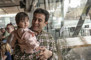 Man holding toddler and smiling.