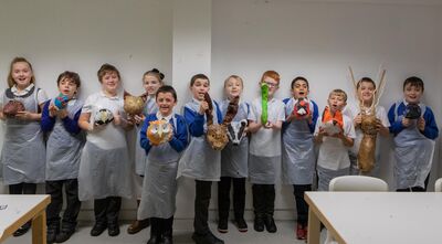 School children holding their animal sculptures