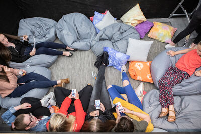 Aerial shot of kids on phones sitting on beanbags