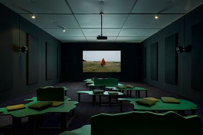 Dark room with film on screen, and seating in the shape of the UK