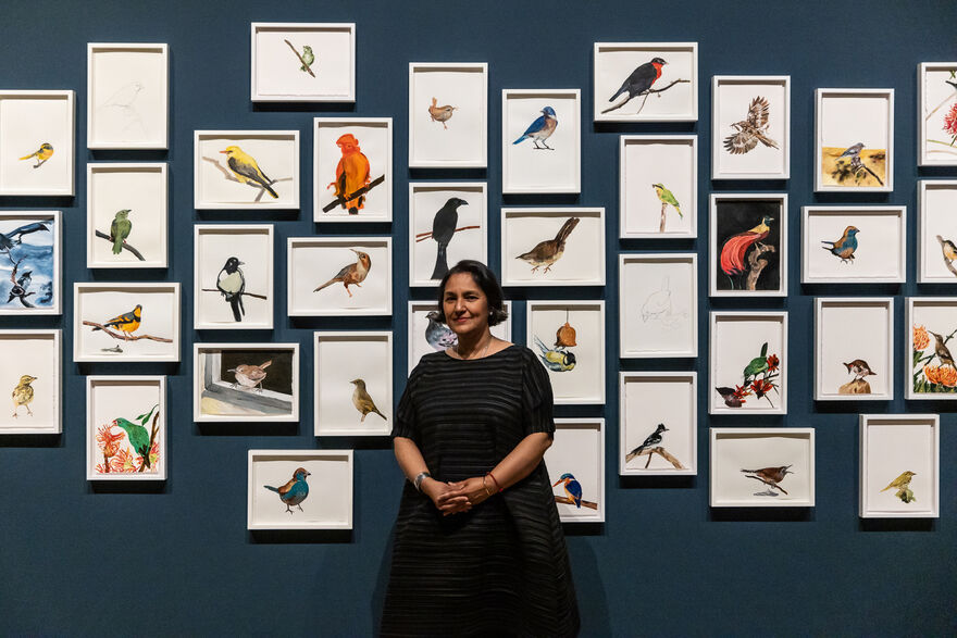 Artist in front of drawn birds