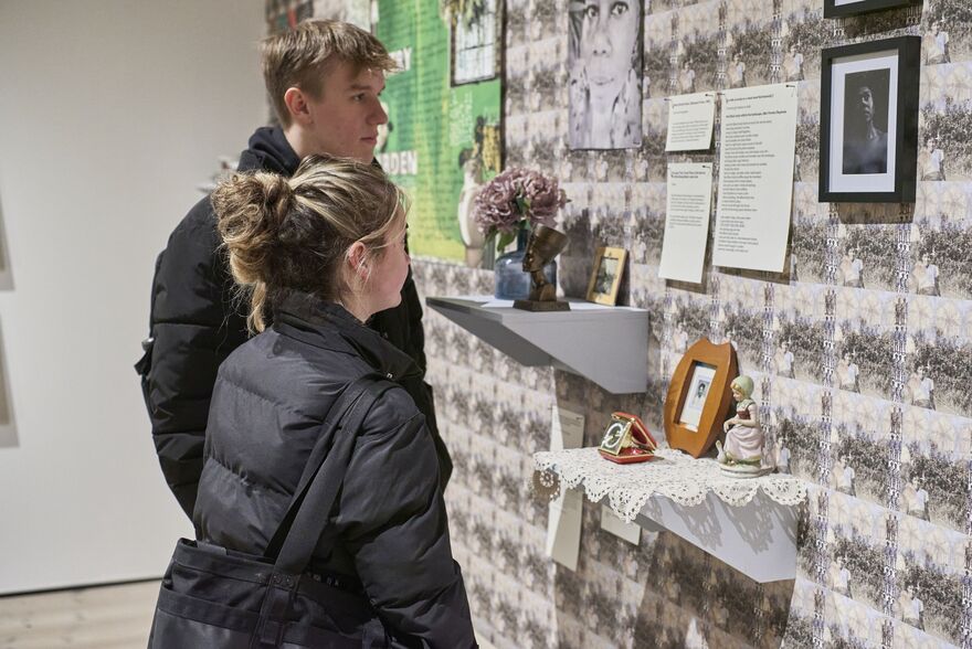 Two visitors looking at artwork