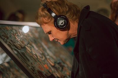 Person with headphones looking at artwork