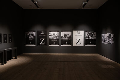 A dark room with spotlights highlighting posters
