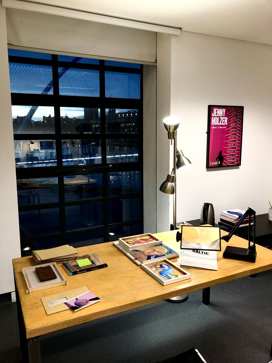 Table facing window, with artworks