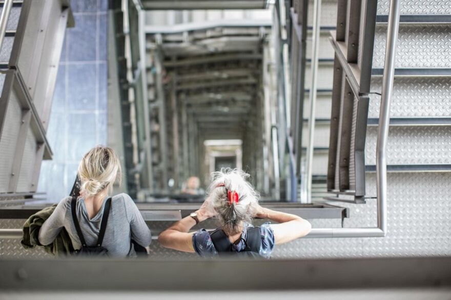 Two adults looking down the staircase