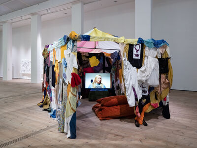 Tent made out of fabric with a television playing inside