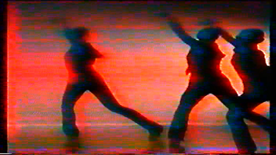 Silhouettes of people dancing with an orange background.