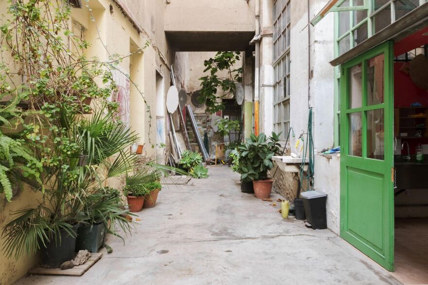 Alley with green plants and a green door