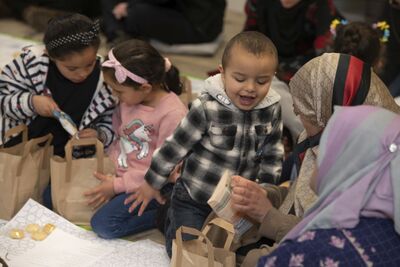 Children looking at bags and food with smiles on their faces