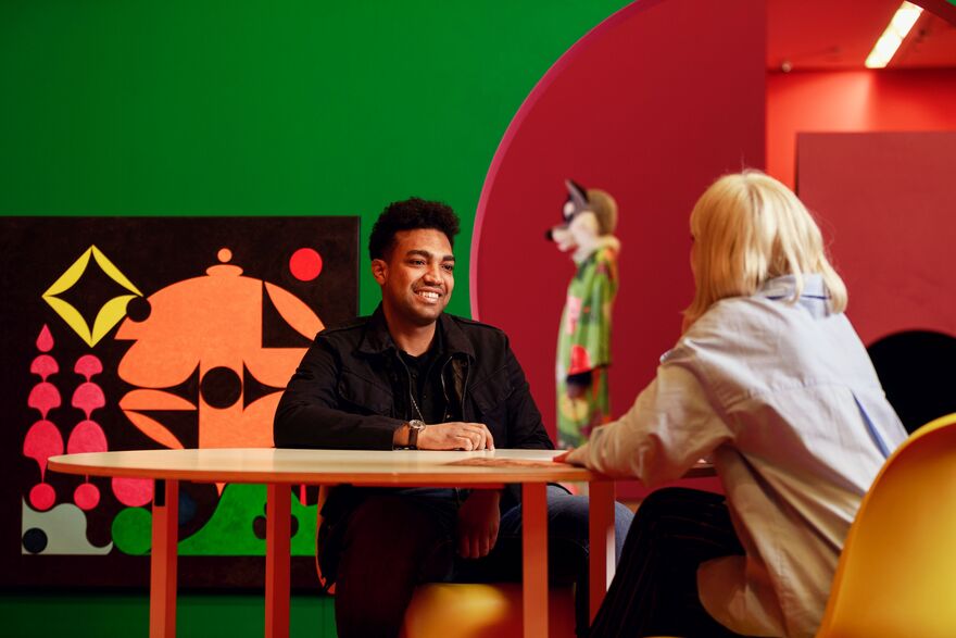 Two visitors sat at table chatting