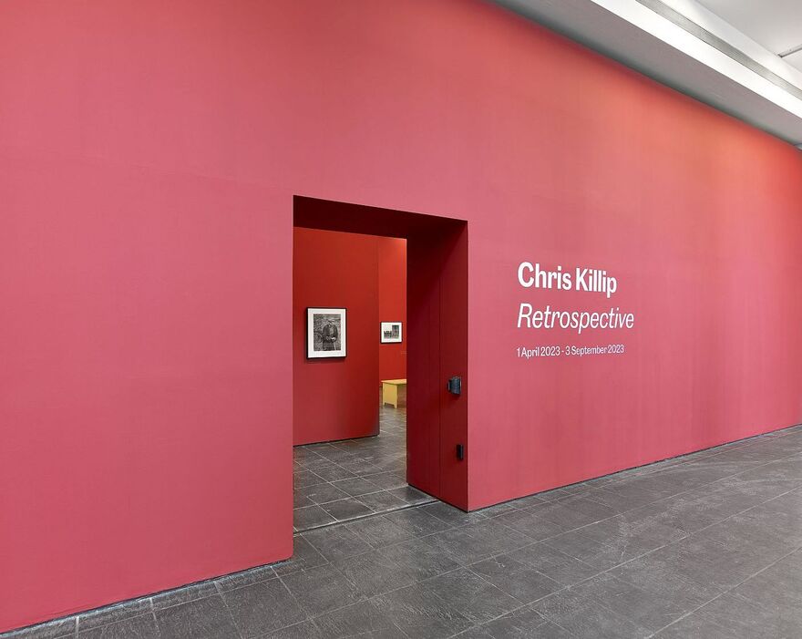 Red wall with title of exhibition