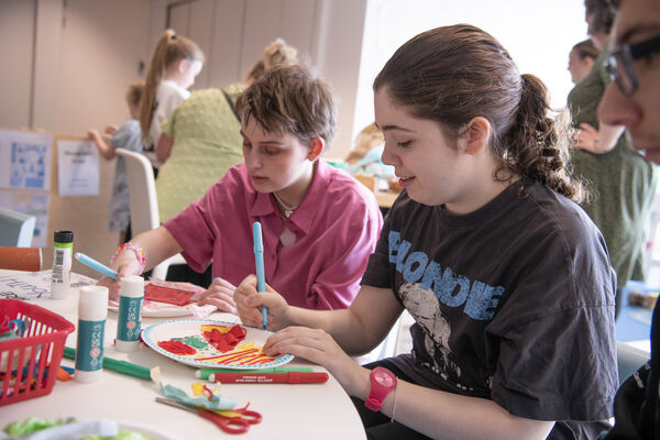 Two people sitting down crafting