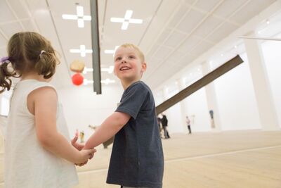 Two children holding hands in exhibition