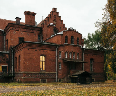 Old brick building surrounded by trees and fallen leaves