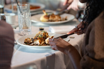 Person cutting into a plate of food.