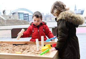 Two children playing with a sand pit