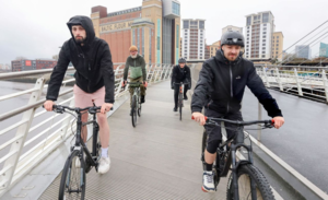Men riding their bikes on a bridge 