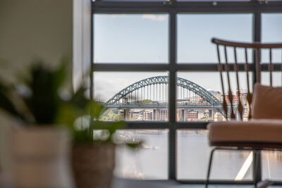 View out a window on a sunny day of the River Tyne and the Tyne Bridge.