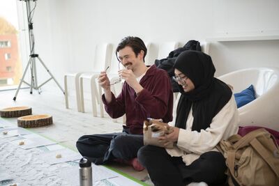 Two people sat on the floor, laughing. 