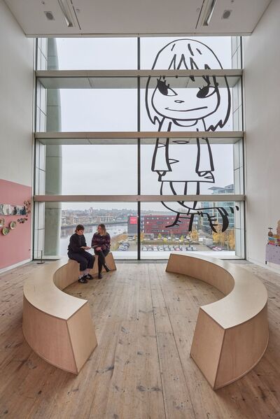 Two people sat on curved benches in Learning Lounge