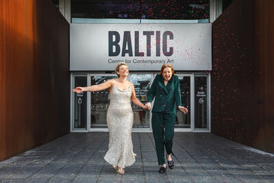 Two women stood outside Baltic smiling and under confetti