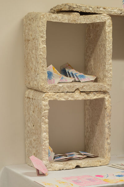 Foldable origami style artwork displayed on shelves.