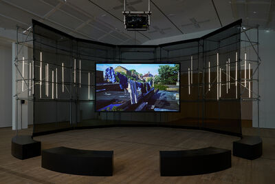 A screen depicting washing hanging, there are benches in front of the screen and lights behind the screen