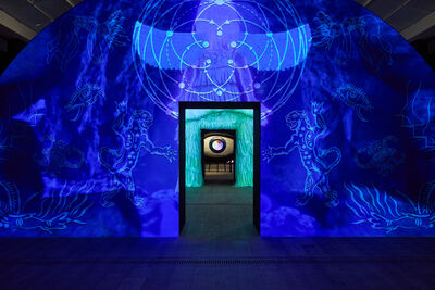 Installation of two archways with doors looking through to an eye. There are vibrant blue projections on the archways.