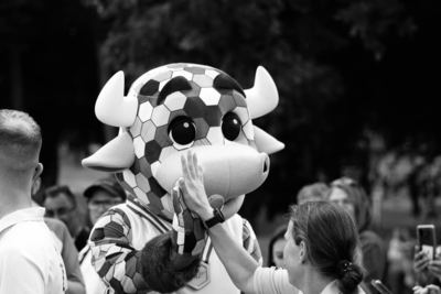 A bull mascot high fives a person.