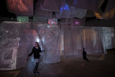 Children running through sheets of fabric. 