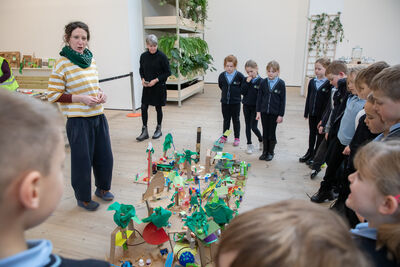 Children gather round a paper sculpture