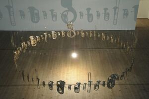 Flattened brass instruments, flattened and hanging in a circle. 