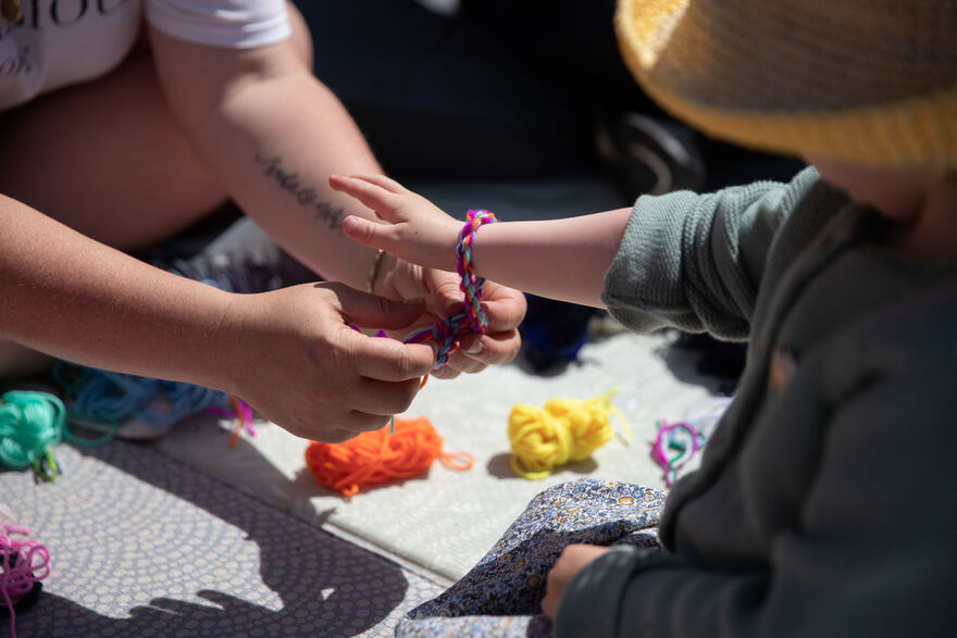 Adult tying a bracelet around a child's hand