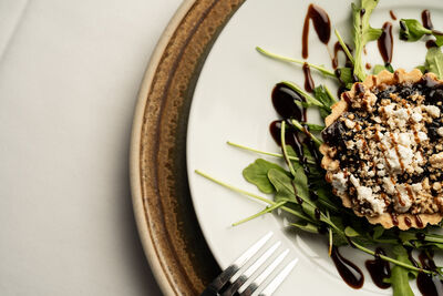 A feta and balsamic tart presented on a white plate.