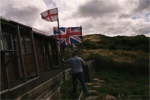 Figure in countryside holding union jack flag