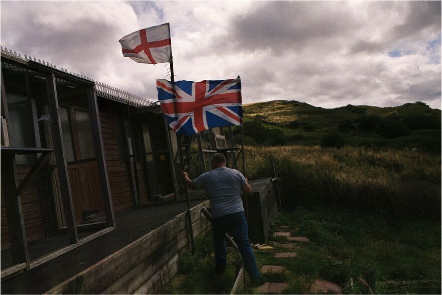 Figure in countryside holding union jack flag