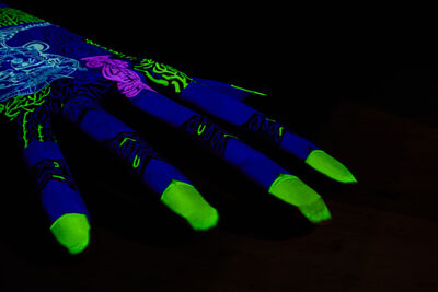 Large sculpture of a hand with blue, pink and green projections on it.