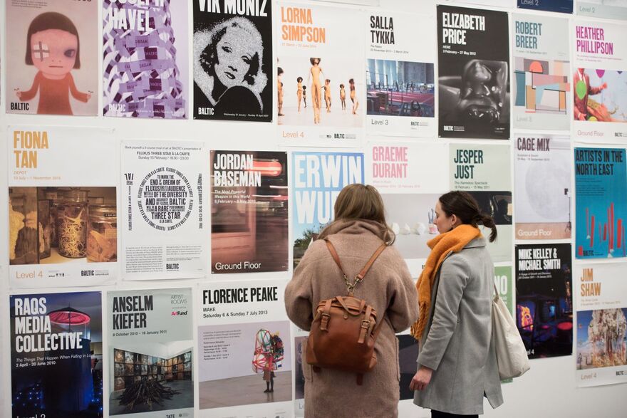 Two people looking at exhibition posters