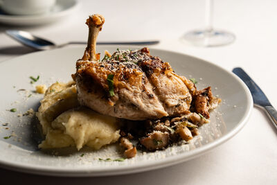 A roast chicken dinner beautifully presented on a white dinner plate.