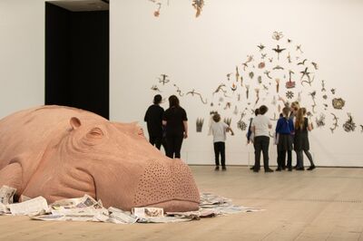 Large clay hippo, and school children looking at artwork behind