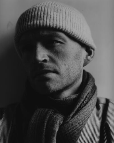 Portrait of figure wearing hat.