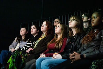 Eight people sat in the cinema looking at the screen.