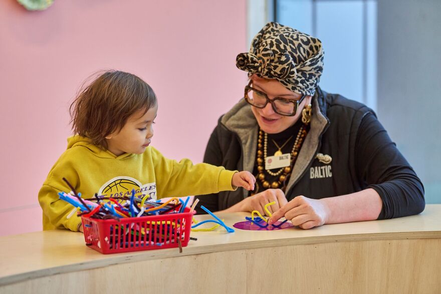 Baltic Crew member crafting with young visitor