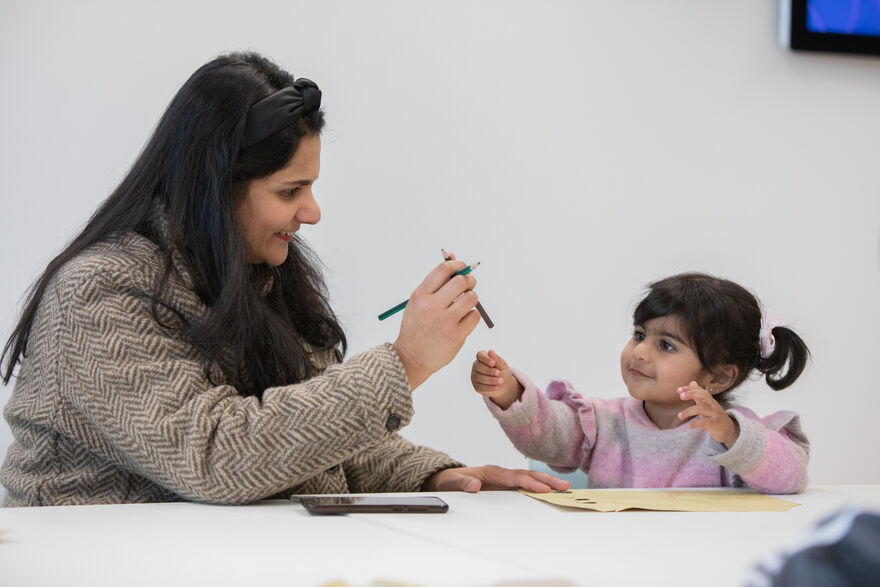 Adult handing toddler pencil