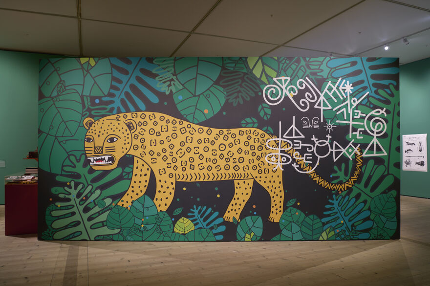 Green leafy wall with a graphic drawing of a leopard