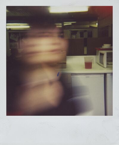 Polaroid of a woman moving so her face blurs.