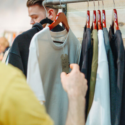 Person looking through rail of t-shirts
