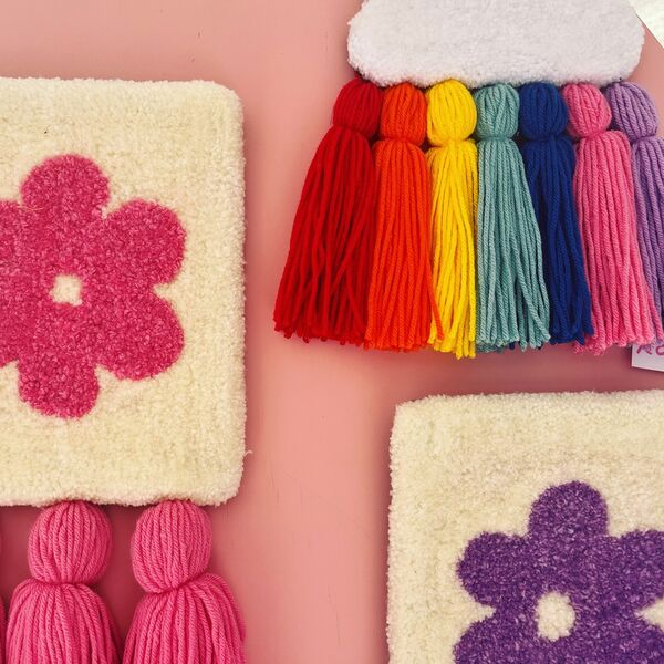 Square flower hangings with colourful yarn tassels.